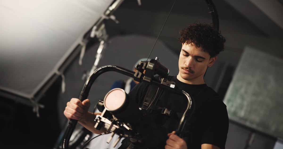 Cinematographer operating a camera in a production studio